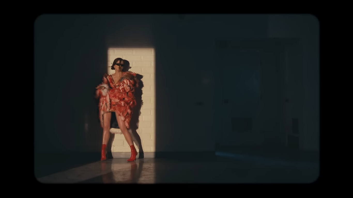 gaya kece lisa 'blackpink' dan  rosalía di music video 'new woman', 1. Lisa mengawali video musiknya dengan penampilan fierce. Memancarkan aura dark feminine, Ia pakai mantel hitam yang dikenakan di atas bra berkilauan dan celana pendek mikro yang serasi, dilengkapi dengan kalung hati metalik dan sepatu boots setinggi lutut., 2. Tampil dengan gaya a la gilded girl, Lisa pakai atasan metalik dan rok mini warna gold yang serasi. Suede boots warna nude dari Maison Margiela melengkapi gayanya., 3. Rosalía dengan gaya khasnya berikan sentuhan modern pada outfit yang terinspirasi dari flamenco. Ia mengenakan dress merah dengan potongan asimetris dengan garis leher rendah dipadukan dengan ankle boots merah. Warna merah yang berani menciptakan siluet dramatis yang kuat dan feminin., 4. Gaya Rosalía selanjutnya pakai bodysuit warna putih dengan motif floral merah dipadukan dengan heels hitam yang memancarkan nuansa vintage., 5. Dalam salah satu adegan, Lisa tampil fierce mengenakan pakaian bulu-bulu hitam, yang dipadukan dengan riasan mata gelap dan tatanan rambut sleek. , 6. Lisa bergaya edgy dengan atasan korset, celana kargo low-rise dan belt putih bergaya Y2K. Di adegan lainnya Ia melengkapi penampilannya dengan mantel bulu yang terinspirasi dari gaya Mob Wife yang vintage sekaligus berani., 7. Seperti Yin&amp;Yang, Lisa dan Rosalía mengenakan outfit hitam putih dengan dress berbahan sheer yang flowy., 8. Dalam adegan terakhir, Rosalía pakai mantel bertekstur warna pink yang dipadukan dengan kacamata biru reflektifnya yang memberi sentuhan modern. Di sampingnya, Lisa tampil kontras dengan outfit yang lebih edgy, mengenakan jaket kulit hitam dan putih dengan kacamata bergaya futuristik.