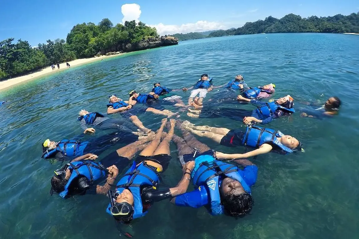 menikmati wisata snorkeling di pantai tiga warna