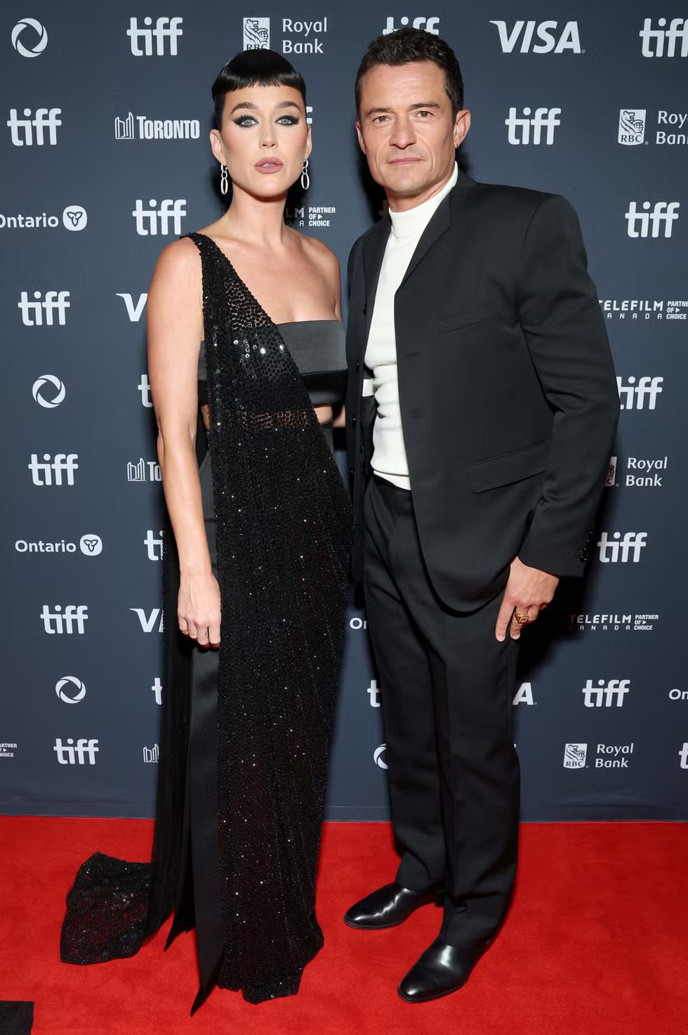 12 gaya terbaik seleb di toronto international film festival 2024, 1. Vanessa Kirby tampil mewah mengandalkan gaun strapless merah berbahan satin yang dilengkapi dengan aksen trail., 2. Sydney Sweeney tampak elegan sekaligus chic dalam balutan dress warna putih dengan aksen floral 3D yang dirancang khusus oleh Erdem., 3. Zoe Saldana mengenakan lace dress menerawang dari Armani Privé yang dikombinasikan dengan perhiasan dari Cartier., 4. Margaret Qualley datang dengan tampilan yang unik mengenakan outfit dari Chanel. Sang aktris mengenakan dress warna mint dengan aksen pita yang menampilkan inner warna hitam., 5. Katy Perry datang bersama Orlando Bloom dengan gaya yang serasi. Ia mengenakan dress dari Celine yang berkilauan dengan potongan one-shoulder, sementara Orlando Bloom tampak keren dengan suit dan high-neck jumper., 6. Jennifer Lopez tampil menawan dalam balutan gaun warna nude yang flowy rancangan Chloé dipadukan dengan boots senada bersiluet slouchy., 7. Chloe Sevigny memilih gaun strapless putih dengan aksen lace dari Balenciaga untuk melengkapi gayanya di karpet merah., 8. Florence Pugh memilih tampilan glamor dalam balutan ballgown pink karya Tamara Ralph yang dihiasi puta hitam di tengahnya., 9. Daisy Edgar Jones tampil elegan mengenakan gaun floaty berdetail pleats dari Gucci yang dikombinasikan dengan perhiasan Tiffany & Co., 10. Tampil dengan gaya chic, Ana de Armas mengenakan dress pink dengan detail rok beraksen lace dari Louis Vuitton., 11. Amy Adams andalkan gaun navy dengan aksen embellishment yang dirancang khusus oleh Prada., 12. Selena Gomez mengenakan dress hitam berdetail sequin dari Rodarte yang dipadukan dengan perhiasan dari Tiffany & Co.