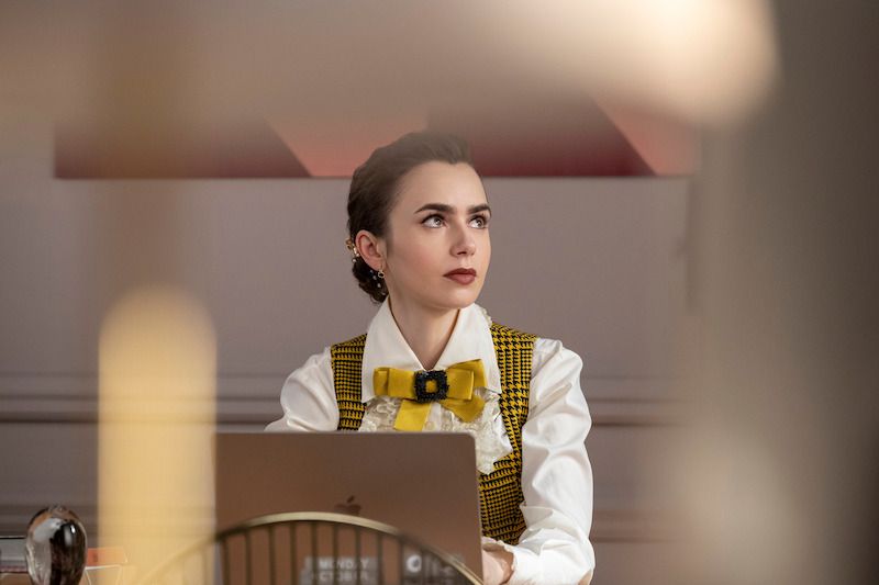 7 tren fashion populer yang ada di serial emily in paris musim 4, 1. Color block atau pakaian tabrak warna beberapa kali terlihat dikenakan Emily Cooper. Pada musim keempat, Emily Cooper kembali mengenakan OOTD tabrak warna yang memadu-padankan satu set pakaian warna hijau zamrud motif floral dari Philosophy di Lorenzo Serafini dan mini cardigan rajut merah muda dari Jacquemus., 2. Sedangkan untuk motif, karakter Emily Cooper tampaknya sedang menyukai pakaian bermotif polkadot. Salah satu scene yang memperlihatkan Emily Cooper mengenakan gaun midi motif polkadot dari Vivienne Westwood menjadi bukti jika motif tersebut masih diminati tahun ini., 3. Koleksi pantsuit satu warna juga tidak kalah populer dalam serial Emily in Paris. Beri kesan girl boss pada sang karakter, pantsuit bersiluet slim warna biru dari Barbara Bui terlihat semakin chic ketika Emily Cooper padu-padankan bersama tas tangan ikonik jenis Alpha dari Pierre Hardy., 4. Tidak lengkap rasanya jika tidak membahas soal aksesori tambahan yang melengkapi penampilan karakter Emily Cooper. Meramaikan tren fashion coquette, Emily Cooper memilih dasi pita kuning dengan aksen buckle manik-manik hitam sewaktu mengenakan setelan kemeja ruffle putih dan di-layer bersama dress senada motif houndstooth., 5. Selain berbagai macam model topi, headband berukuran lebar warna hitam minimalis tidak lepas dari perhatian netizen. Meski terlihat sederhana, headband klasik yang dikenakan karakter Emily Cooper ini bisa membuat look nostalgia seperti Brigitte Bardot di tahun 60-an., 6. Berbicara soal nostalgia, preppy look monokrom Emily Cooper juga mengingatkan netizen dengan sosok ikon Audrey Hepburn. Lewat padu-padan kemeja putih dibalut jaket motif kotak-kotak dengan scarf biru di leher, rok midi pleated, sepatu balet dan cross body bag coklat, OOTD ini begitu mencerminkan ciri khas gaya Audrey Hepburn semasa muda dulu., 7. Emily Cooper terlihat percaya diri ketika mengenakan berbagai macam item tas berbentuk unik. Salah satunya, tas merah minimalis bersiluet kupu-kupu dari Peter Nitz yang dikenakannya bersama off-shoulder top biru motif polkadot serta celana pendek gelap.