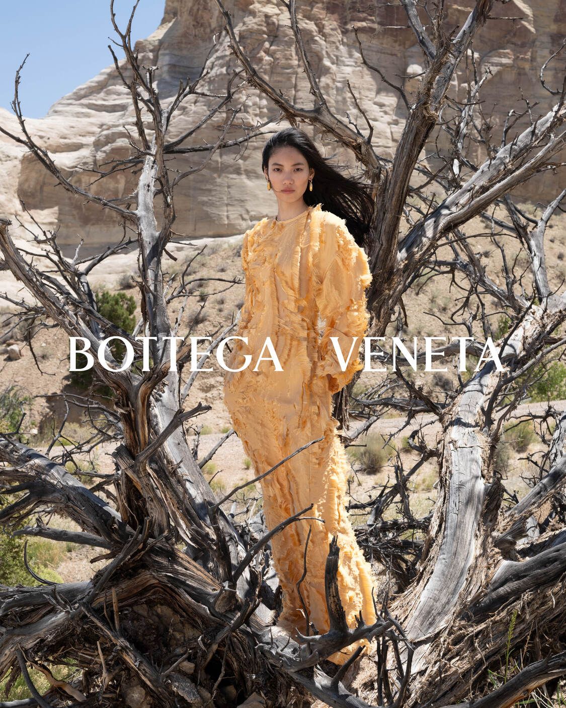 bottega veneta merilis winter campaign 2024 terbaru, 1. Campaign terbaru Bottega Veneta untuk musim dingin 2024 menciptakan dialog visual antara keindahan gurun yang mencolok dan visi kemewahan rumah mode tersebut., 2. Kali ini direktur kreatif Matthieu Blazy berkolaborasi dengan fotografer Alec Soth untuk menonjolkan koleksi musim dingin 2024. Dengan latar Nevada dan Utah, model Mariacarla Boscono, Zayna Cisse, hingga Imaan Hammam menyatu dengan lanskap tandus dalam balutan koleksi terbaru Bottega Veneta., 3. Bebatuan yang menjulang tinggi, jalanan yang kosong hingga vegetasi gurun yang tangguh menjadi latar yang kontras untuk menampilkan deretan koleksi musim dingin, mulai dari rok bertekstur flowy hingga mantel struktural., 4. Aksesori khas Bottega Veneta dengan tekstur intrecciato-nyaditampilkan sebagai lambang ketahanan flora gurun yang tangguh sekaligus rumit. Sesuai dengan konsep Matthieu Blazy kali ini tentang introspeksi, ketahanan dan kelahiran kembali, yang mengambil inspirasi lanskap kering dan tandus sebagai tempat kehidupan bertahan dan berkembang., 5. Campaign musim dingin Bottega Veneta merupakan bentuk eksplorasi visual terhadap perpaduan craftsmanship, desain dan alam yang saling melengkapi. Visualnya terungkap dengan hamparan gurun yang tak berujung, sebagai lambang tanpa batasan.