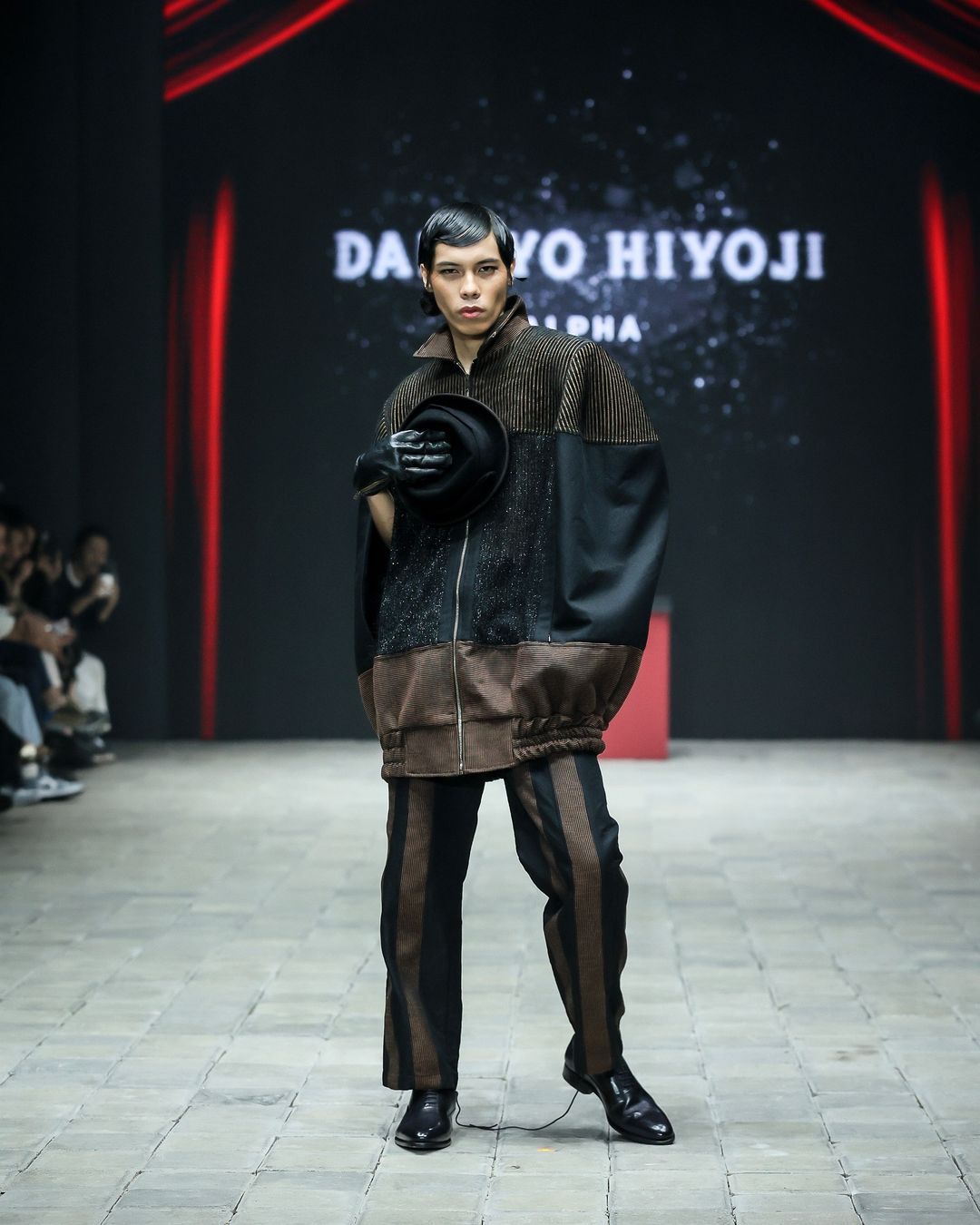 danjyo hiyoji hadirkan esensi kabaret yang semarak di pimfw 2024, 1. Koleksi ‘Monsieur’ dibuka dengan deretan look yang menampilkan setelan blazer yang pas dan celana panjang yang bervolume. Aksesori scarf dengan konstruksi kaku yang seolah tertiup angin memberi dimensi ekstra yang unik di sejumlah look., 2. Koleksi ini menangkap sensasi dari pertunjukan kabaret dengan menata ulang siluet busana pria klasik dengan volume yang berlebihan dan lapisan yang didekonstruksi., 3. Potongan asimetris dan kain berlapis menciptakan kontras visual yang mencolok. Elemen-elemen yang ceria seperti lengan yang besar dan motif yang dramatis menambahkan sentuhan unik yang memberi kejutan dalam koleksi ini., 4. Dwi Sasono jadi salah satu muse yang berjalan di runway, memamerkan koleksi setelan jas dengan sentuhan elemen floral dan celana serba putih yang dipadukan dengan inner warna silver dan scarf yang dirancang dengan konstruksi kaku., 5. Adinia Wirasti muncul dengan penampilan yang ikonik seperti di film The Greatest Showman. Mengenakan setelan jas yang mencolok dengan siluet yang dramatis, mewujudkan daya tarik kabaret yang serba glamor.