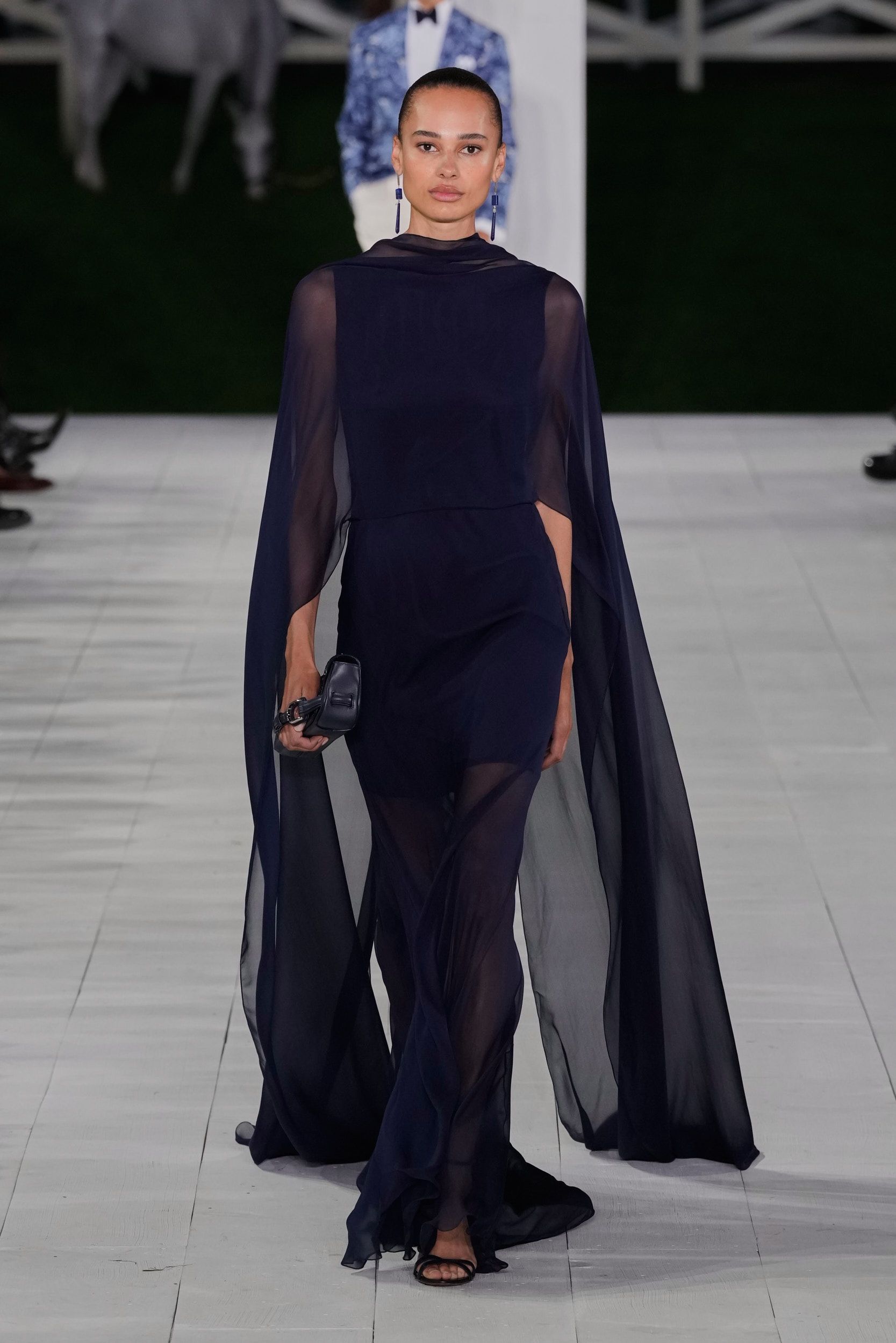 ralph lauren perlihatkan kehangatan keluarga di panggung s/s 2025, 1. Tren fashion “boho chic” beberapa kali terlihat di atas panggung runway Ralph Lauren Spring/Summer 2025. Meski tidak menerapkan motif bold, Ralph Lauren memanfaatkan satu set perhiasan batu permata serta belt berukuran lebar sebagai pelengkap look., 2. Mengutamakan sisi elegan seorang perempuan, koleksi terbaru gaun maxi milik Ralph Lauren didesain dengan sentuhan manis dari aksen taburan manik-manik, pola bunga-bunga, sampai tambahan cape untuk kesan dramatis saat hadiri acara formal., 3. Tidak hanya motif garis-garis, Ralph Lauren juga menyelipkan berbagai macam bentuk motif kotak-kotak yang disatukan dalam bentuk rok panjang bersiluet ekor putri duyung dengan konsep patched (tambalan)., 4. Salah satu fashion item unik dan (mungkin) jarang ditemukan dari koleksi terbaru Ralph Lauren adalah outer blazer warna warm tan yang didesain mirip seperti anyaman tanpa memiliki ornamen tambahan lainnya., 5. Dari awal hingga menjelang penutupan, model perempuan Ralph Lauren terus memperlihatkan berbagai macam model anting chandelier yang didominasi warna perak, navy dan putih., 6. Pada pertengahan show, Ralph Lauren mulai memperlihatkan suasana ceria khas musim panas lewat konsep pakaian color block (tabrak warna) yang mengkombinasikan palet warna terang, seperti kuning mustard dan biru gelap serta hijau dan orange., 7. Usung tema keluarga cemara, tidak heran jika peragaan busana Ralph Lauren Spring/Summer 2024 menghadirkan beberapa model cilik yang ikut berpartisipasi di atas runway bersama model dewasa dengan mengenakan setelan pakaian senada., 8. Masuk dalam jajaran koleksi tas terbaru Ralph Lauren, berbagai siluet tas tangan bermaterial kulit dengan top handle kayu serta aksen buckle yang timeless ternyata mengadaptasi dari kesukaan sang desainer terhadap mobil-mobil jadul.