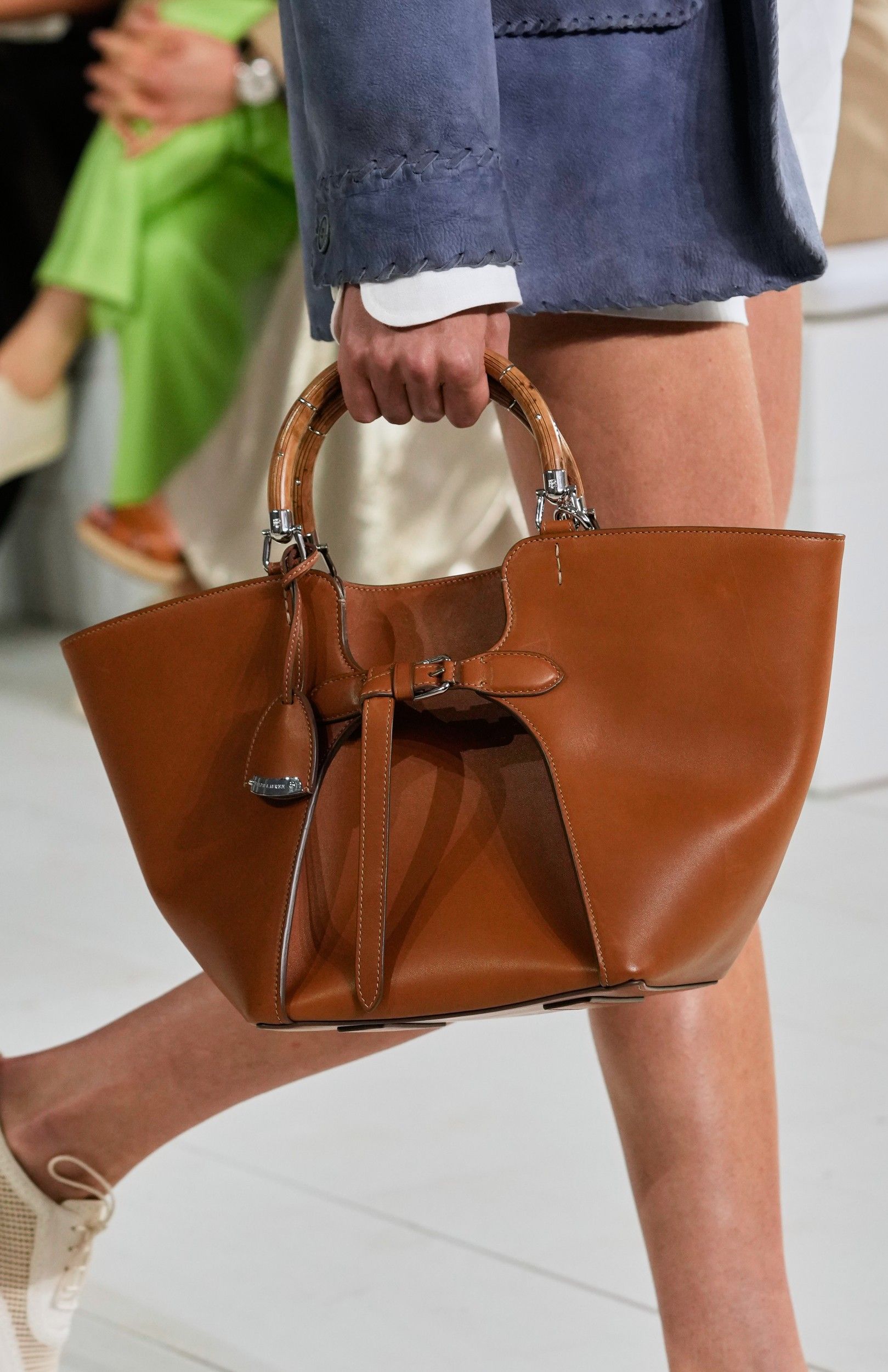 ralph lauren perlihatkan kehangatan keluarga di panggung s/s 2025, 1. Tren fashion “boho chic” beberapa kali terlihat di atas panggung runway Ralph Lauren Spring/Summer 2025. Meski tidak menerapkan motif bold, Ralph Lauren memanfaatkan satu set perhiasan batu permata serta belt berukuran lebar sebagai pelengkap look., 2. Mengutamakan sisi elegan seorang perempuan, koleksi terbaru gaun maxi milik Ralph Lauren didesain dengan sentuhan manis dari aksen taburan manik-manik, pola bunga-bunga, sampai tambahan cape untuk kesan dramatis saat hadiri acara formal., 3. Tidak hanya motif garis-garis, Ralph Lauren juga menyelipkan berbagai macam bentuk motif kotak-kotak yang disatukan dalam bentuk rok panjang bersiluet ekor putri duyung dengan konsep patched (tambalan)., 4. Salah satu fashion item unik dan (mungkin) jarang ditemukan dari koleksi terbaru Ralph Lauren adalah outer blazer warna warm tan yang didesain mirip seperti anyaman tanpa memiliki ornamen tambahan lainnya., 5. Dari awal hingga menjelang penutupan, model perempuan Ralph Lauren terus memperlihatkan berbagai macam model anting chandelier yang didominasi warna perak, navy dan putih., 6. Pada pertengahan show, Ralph Lauren mulai memperlihatkan suasana ceria khas musim panas lewat konsep pakaian color block (tabrak warna) yang mengkombinasikan palet warna terang, seperti kuning mustard dan biru gelap serta hijau dan orange., 7. Usung tema keluarga cemara, tidak heran jika peragaan busana Ralph Lauren Spring/Summer 2024 menghadirkan beberapa model cilik yang ikut berpartisipasi di atas runway bersama model dewasa dengan mengenakan setelan pakaian senada., 8. Masuk dalam jajaran koleksi tas terbaru Ralph Lauren, berbagai siluet tas tangan bermaterial kulit dengan top handle kayu serta aksen buckle yang timeless ternyata mengadaptasi dari kesukaan sang desainer terhadap mobil-mobil jadul.