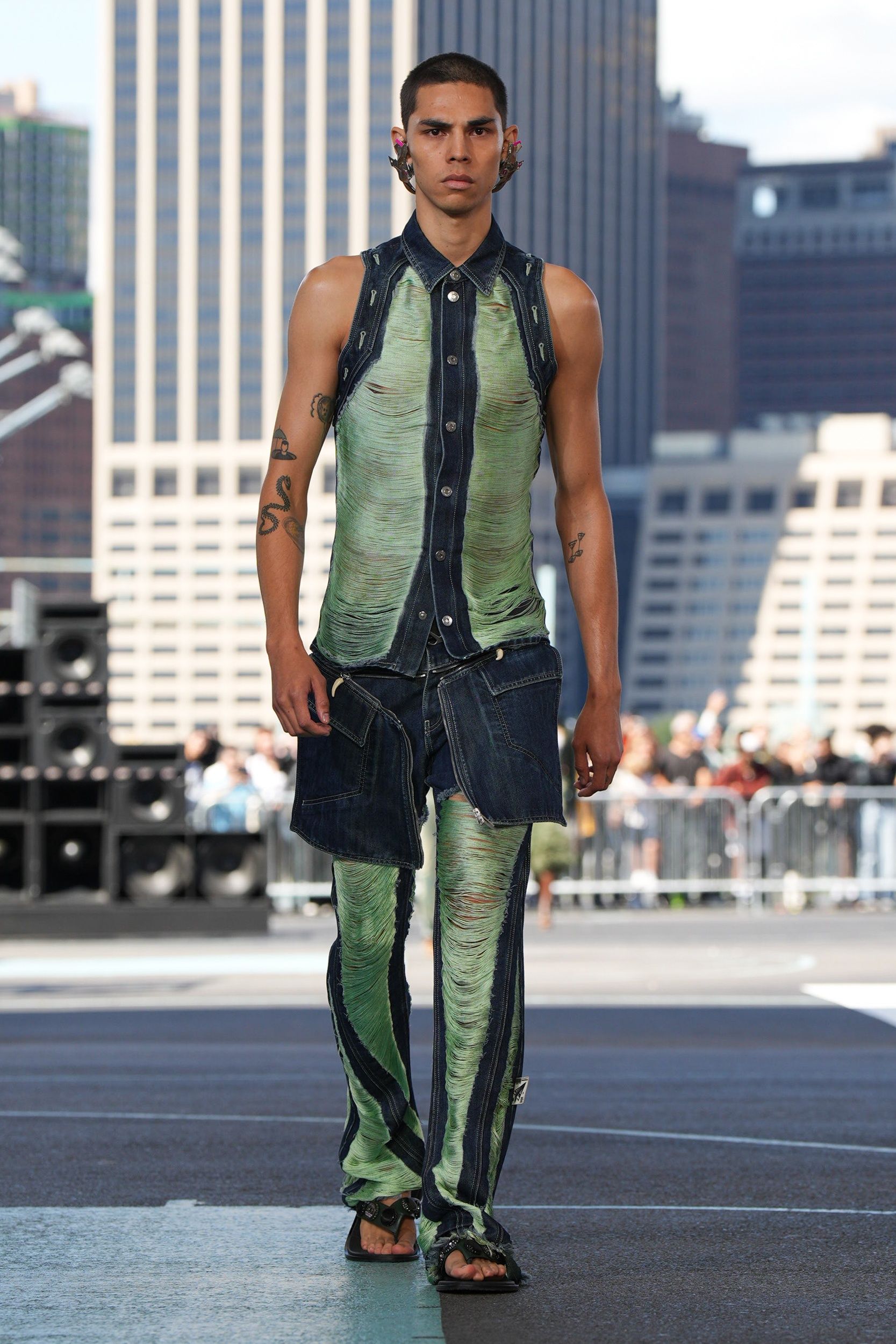 streetwear eksentrik ghana dari off-white sukses debut di nyfw ss 2025, 1. Motif bold warna-warni merupakan detail paling populer yang mewakili ciri khas mode di Ghana. Maka dari itu, pada koleksi Spring/Summer 2025 ini Off-White berkolaborasi dengan seniman Nana Danso dalam menciptakan berbagai macam bentuk motif lukisan mirip grafiti yang diterapkan pada item hoodie, sleeveless t-shirt warna putih serta satu set pakaian sporty serba hitam., 2. Rilis beberapa look denim-on-denim, uniknya Ib Kamara menyempurnakan setelan tersebut dengan detail serutan benang bertekstur halus yang didesain menyatu bersama material denim., 3. Pakaian transparan atau sheer dress terbukti masih menjadi item populer sampai musim semi dan musim panas tahun depan. Ib Kamara memamerkannya dalam wujud satu setelan (crop top panah dan rok midi low-rise) yang didesain menyerupai rantai berkat detail taburan manik-manik silver yang disusun di atas pola kain hitam., 4. Tidak hanya hoodie, Ib Kamara juga menawarkan beberapa koleksi pakaian rajut dengan tutup kepala yang menutupi bagian leher mirip balaclava., 5. Meski tidak banyak memperlihatkan koleksi perhiasan, Ib Kamara memilih sepasang anting metalik bersiluet pesawat sebagai statement point yang diperlihatkan dari awal sampai akhir peragaan busana., 6. Hal menarik lainnya dari koleksi Off-White Spring/Summer 2025 ini adalah kehadiran detail mirip tutup botol minuman kaca yang dimanfaatkan untuk hiasan strappy heels., 7. Koleksi streetwear eksentrik khas Ghana semakin meriah ketika Ib Kamara mempresentasikan koleksi Off-White Spring/Summer 2025 di Pier 2, Brooklyn Bridge Park yang terlihat mewah berkat pemandangan puluhan gedung pencakar langit.
